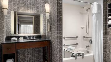 A modern bathroom with a geometric tile backsplash, a dark wooden vanity with a mirror, and a walk-in shower with a glass partition.
