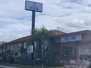Welcome to Buena Park, where lush greenery surrounds a simple, functional building with a red-tiled roof.