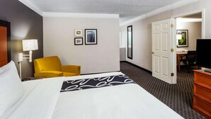 A hotel room with a bed, a yellow armchair, a desk with a chair, and a television. - La Quinta Inn by Wyndham Laredo I-35 (Laredo)