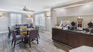 A hotel room with a dining area, a kitchen counter with waffle makers, and a ceiling fan. - La Quinta Inn by Wyndham Laredo I-35 (Laredo)