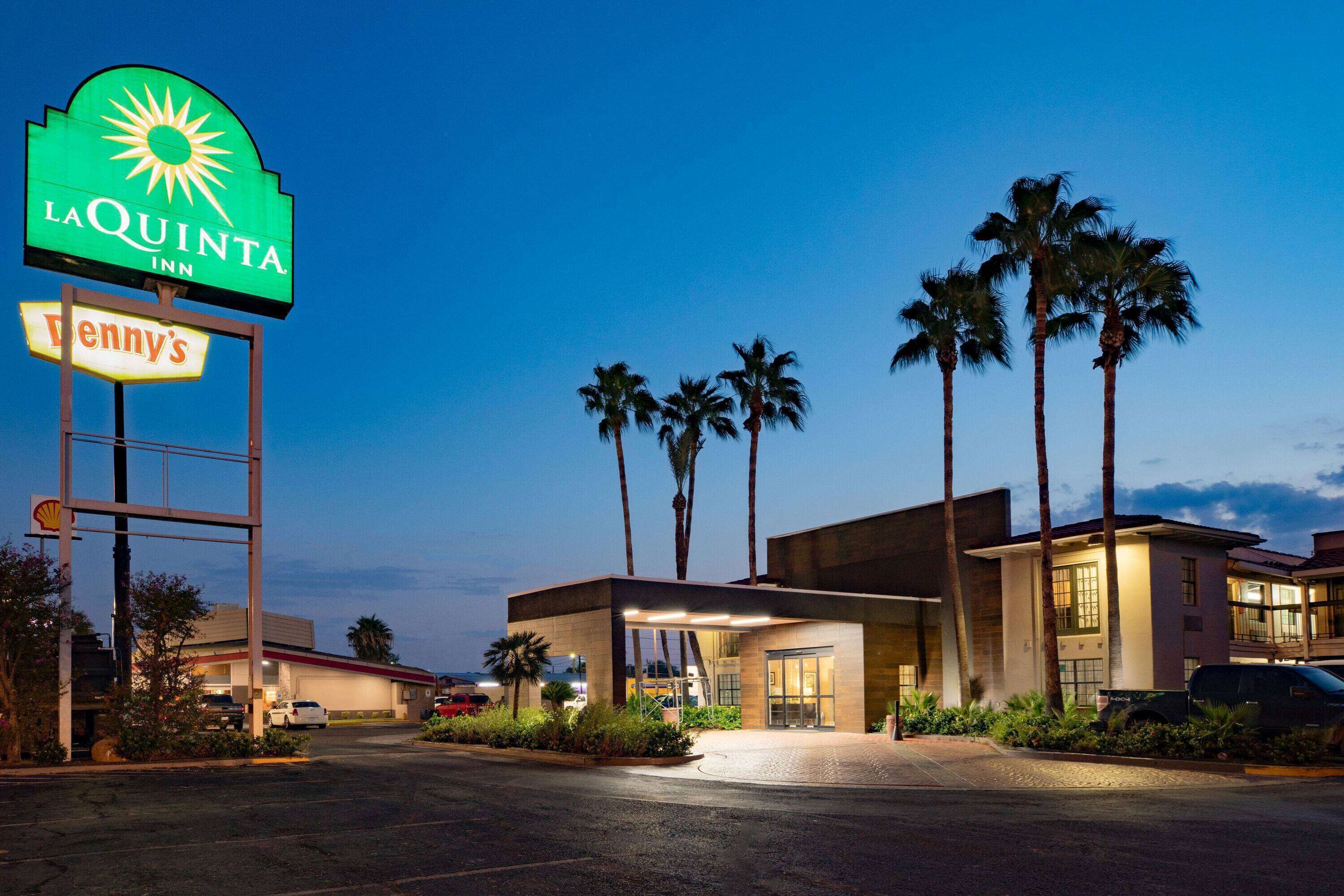 Un hôtel avec une enseigne bien visible indiquant « La Quinta Inn » et un restaurant Tenny's situé à proximité.