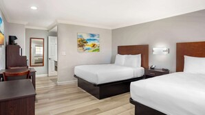 Ein Hotelzimmer mit zwei Betten, einem Schreibtisch, einem Sessel, einem Gemälde an der Wand und einer Tür zu einem anderen Raum.