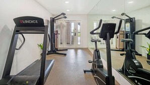 Ein Fitnessraum mit Laufband, Crosstrainer und Ergometer.