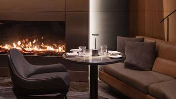 Una sala de estar moderna con chimenea, una mesa de centro redonda, un sofá y un sillón.