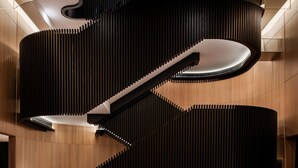 A modern interior with a unique spiral staircase, a dining area with marble tables, and a patterned floor. - Park Hyatt Toronto (Toronto)