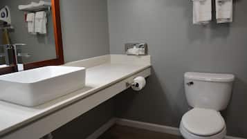 A bathroom with a white sink, toilet, and towel rack.