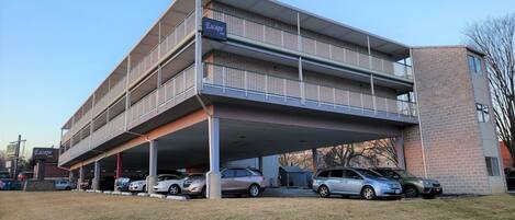 A multi-story building with a covered parking area and a sign indicating it is an Escape Inn.
