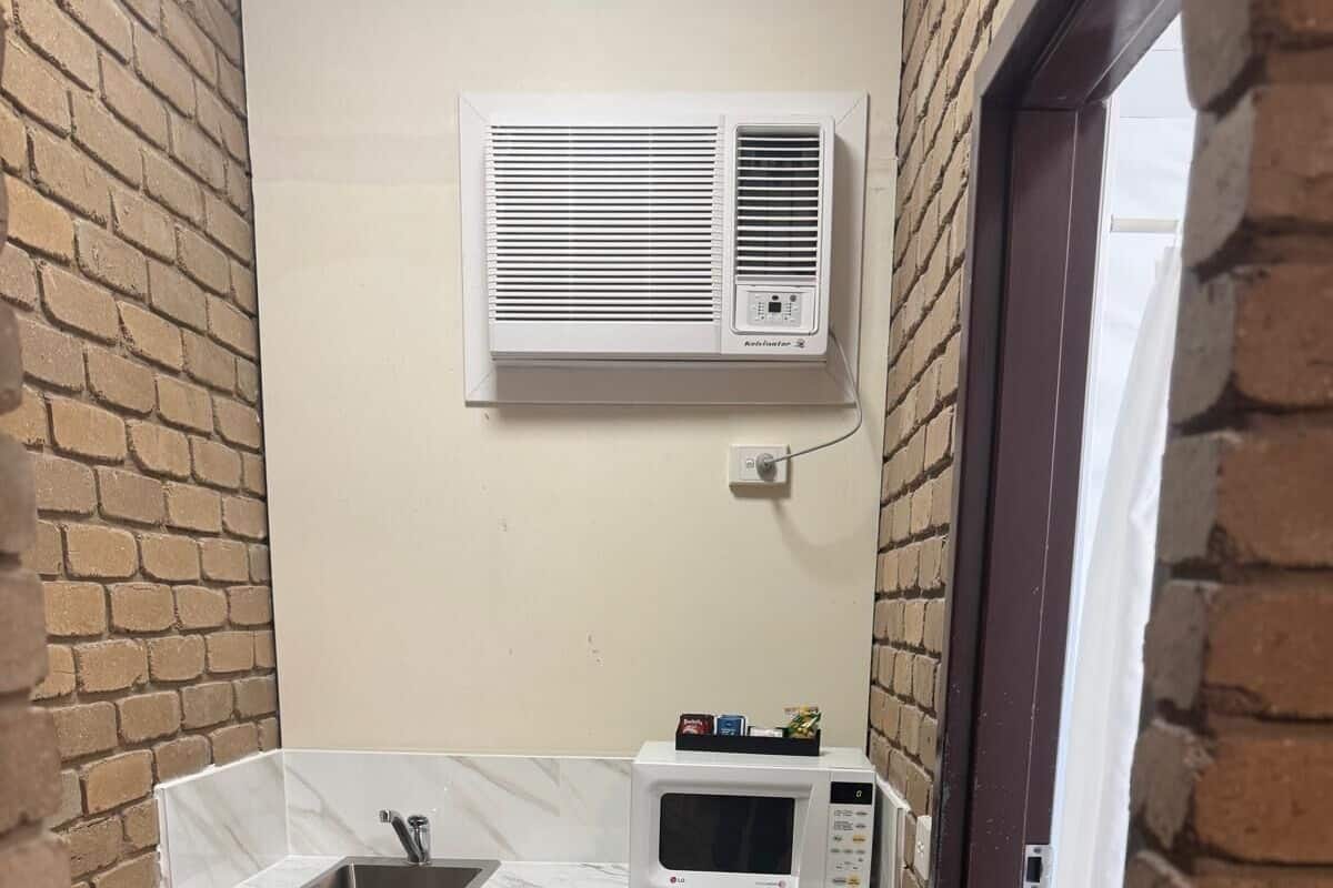 A compact kitchen with a sink, a microwave, and a small refrigerator.