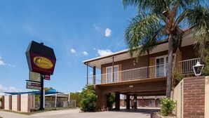 A hotel with a signboard, a covered parking area, and a building with a balcony. - Albury Classic Motor Inn (Lavington)
