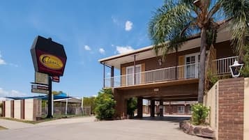 Classic hotel with a two-story facade, featuring a balcony and covered entrance.