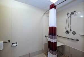A shower with a white and maroon curtain, a handheld showerhead, and a grab bar. - Red Roof Inn Dayton - Fairborn/ Nutter Center (Fairborn)