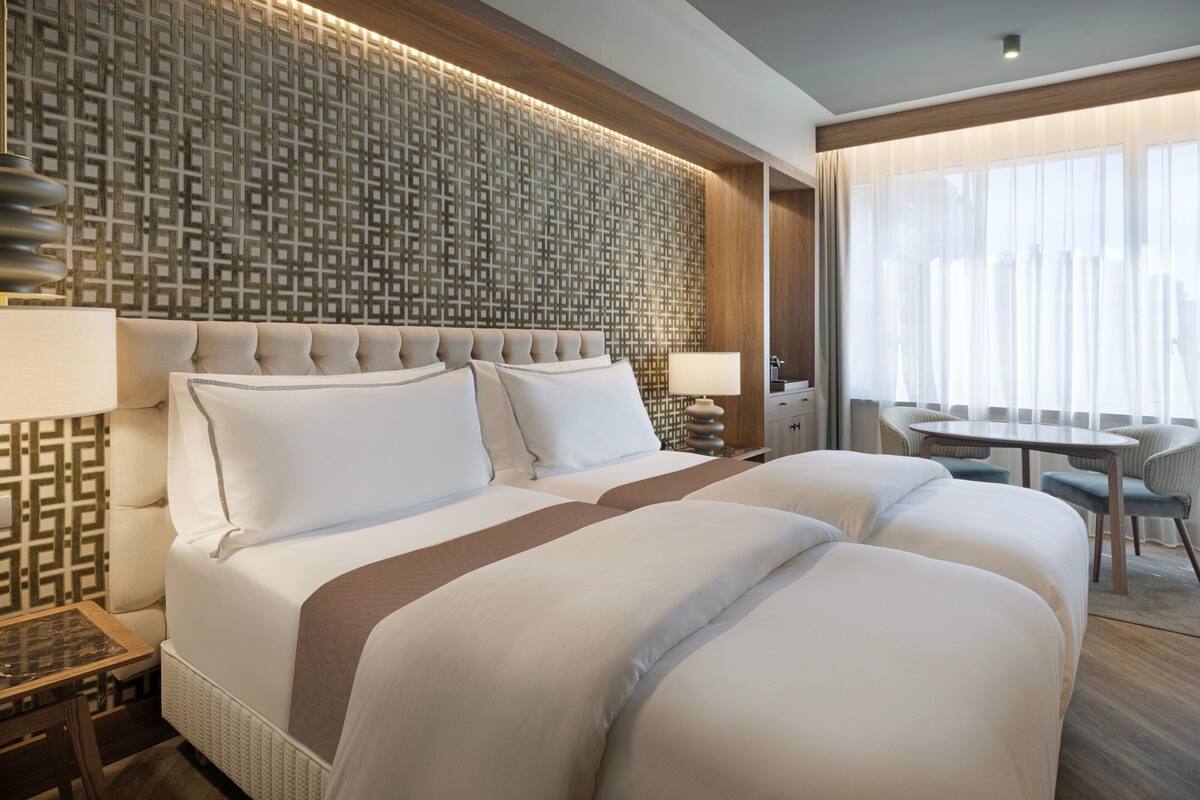 Une chambre d’hôtel avec un grand lit, un bureau et une chaise.