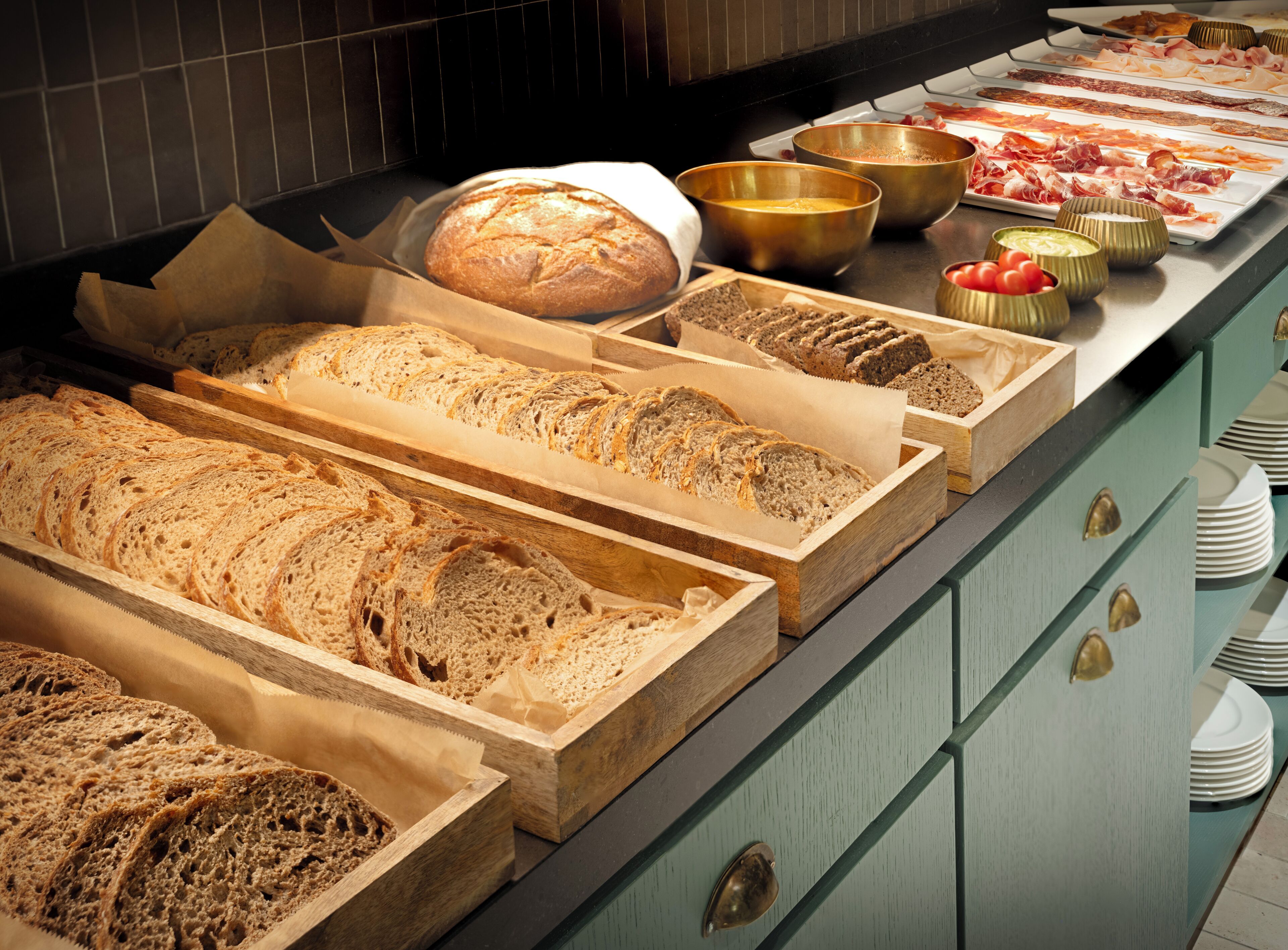 Un buffet proposant différents types de pain et de viandes.