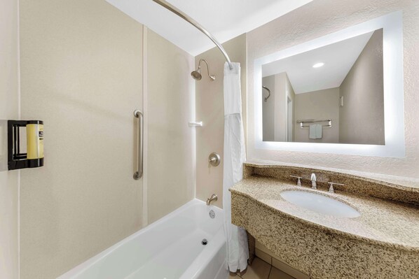 Un baño moderno con bañera, ducha e lavabo con encimera de granito.