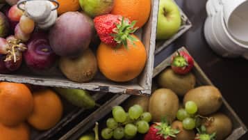 A wooden crate filled with various fruits including apples, oranges, and grapes.