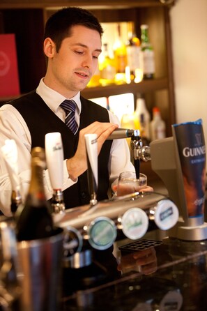 Un cantinero en un bar con múltiples grifos de cerveza y un grifo de Guinness.