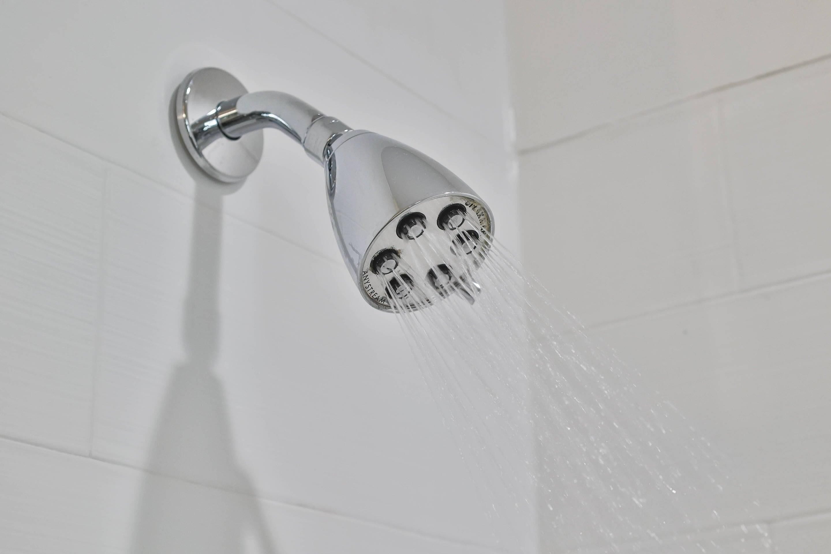 A showerhead with multiple nozzles, mounted on a wall.