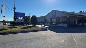 A motel with a 'Free WiFi' sign, a large '6' sign, and a parking lot. - Motel 6 Greenville, NC – ECU-Medical Center (Greenville)