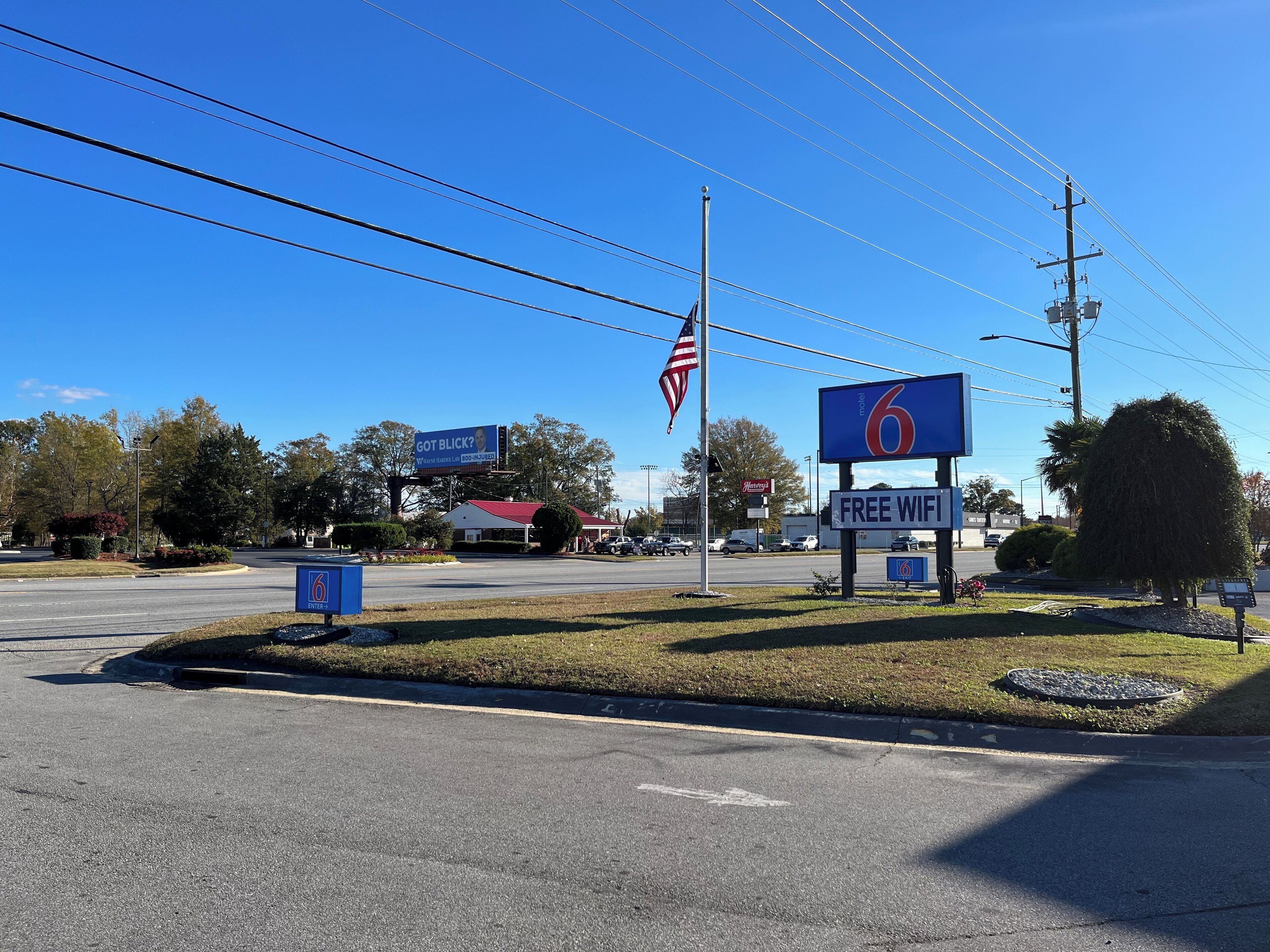 Une enseigne de motel indiquant une offre de « Wi-Fi gratuit », un panneau avec le chiffre « 6 » pour indiquer le numéro du motel, et un drapeau américain.