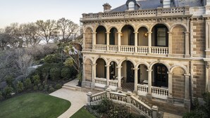 Un bâtiment à deux étages doté de fenêtres en arc de cercle et d’un balcon.