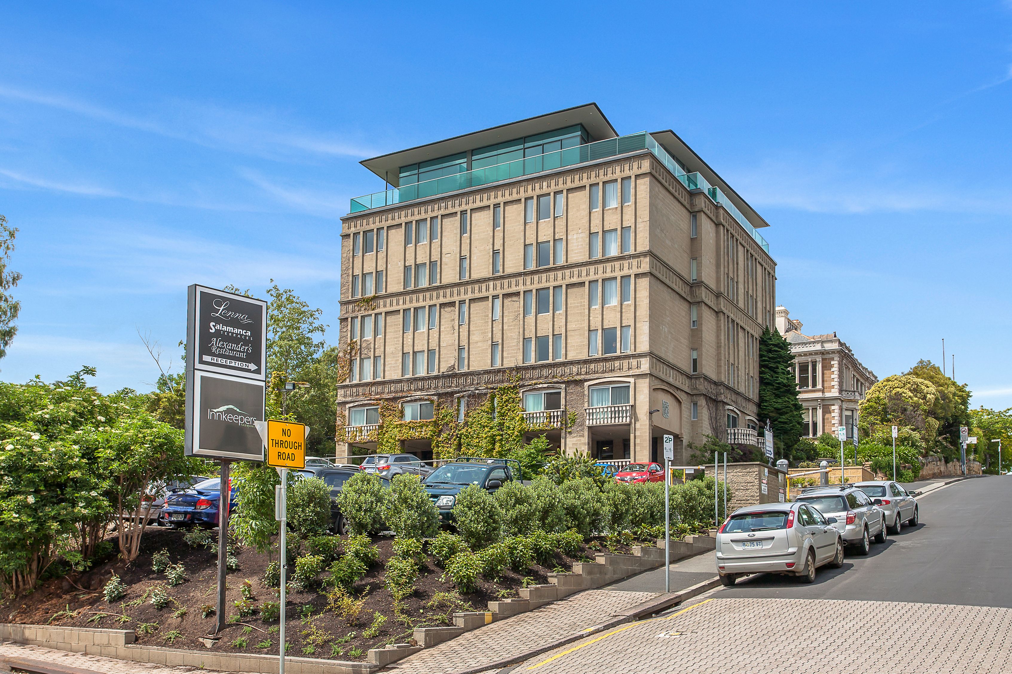 A multi-story hotel with a modern design, featuring a prominent entrance and a landscaped garden area.