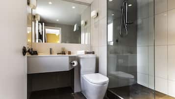 Un baño moderno con inodoro, lavamanos y ducha.