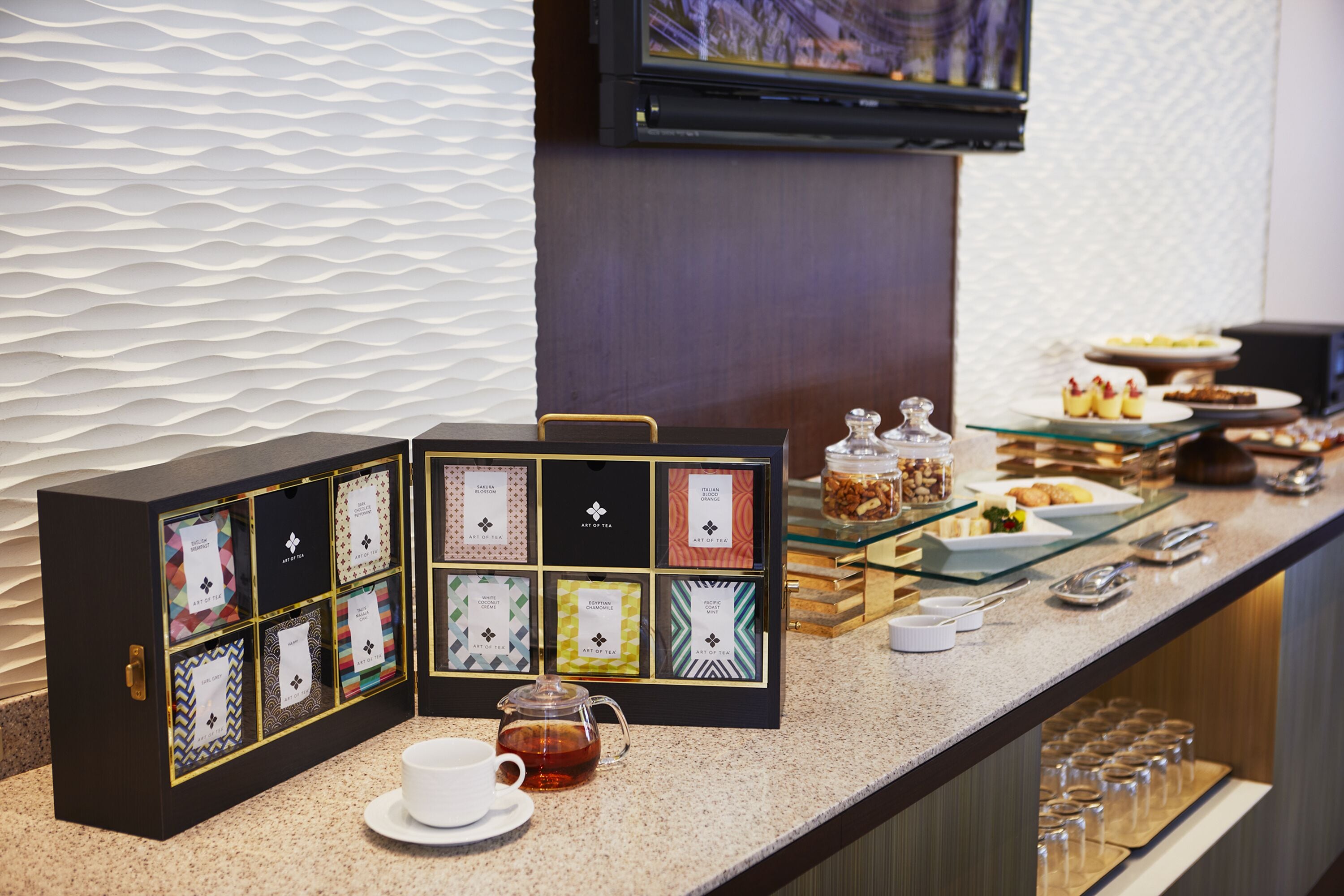 A tea station with a selection of tea boxes and a teapot on a counter.