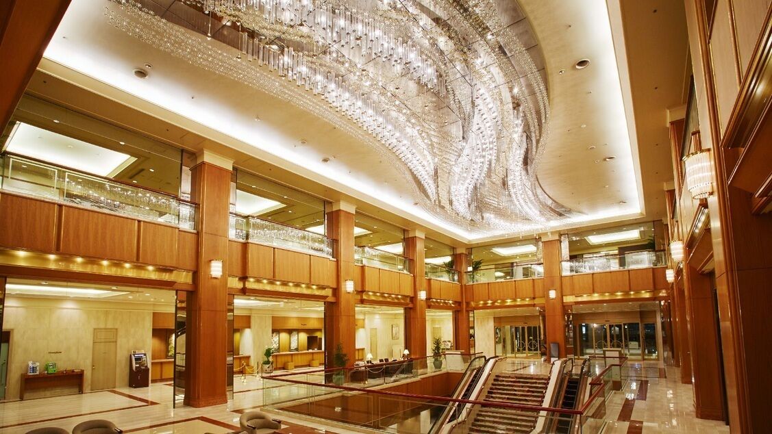 Un hall d’entrée spacieux, agrémenté d’un magnifique lustre, comprenant de nombreux étages et un escalier mécanique central.