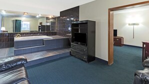 A modern bathroom with a bathtub, a large mirror, and a television.