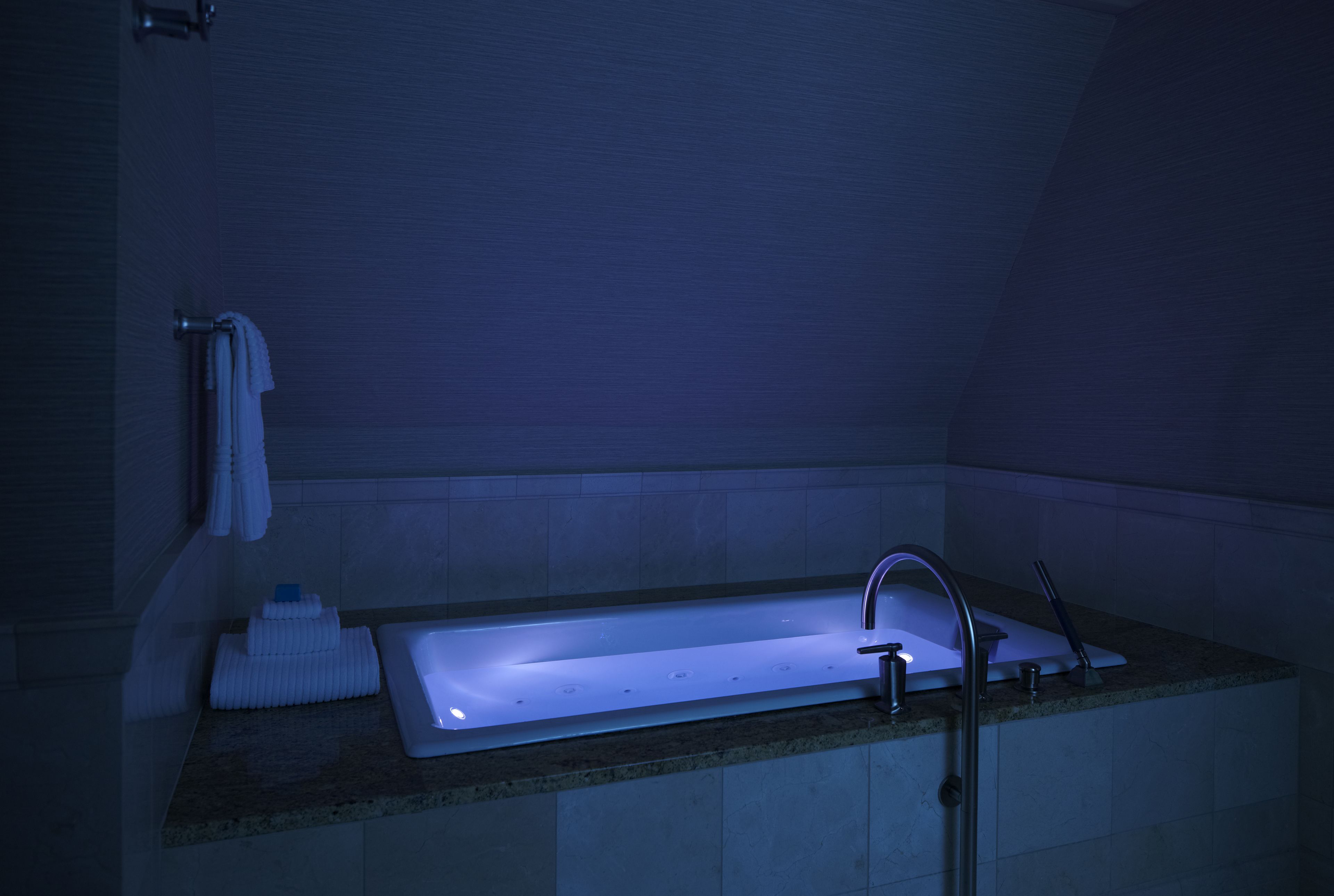 A modern bathroom with a rectangular sink, a towel rack, and a soap dish.