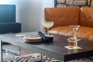 Uma área de jantar moderna com um sofá de couro, uma mesa de jantar com pratos, um guardanapo e dois copos de martini.