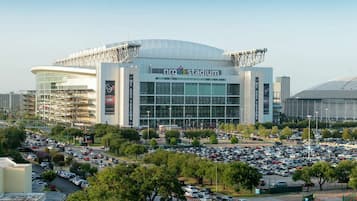 A stadium with a large parking lot and multiple levels of seating.