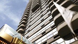 A high-rise hotel with a distinctive curved facade and a sign reading "The Kimberly Suite Hotel".