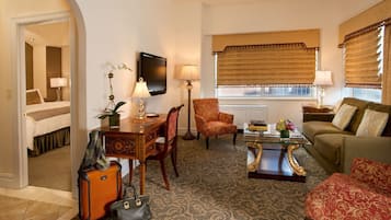 Un salon élégant, doté d’un canapé, d’un fauteuil, d’une table basse et d’un téléviseur.