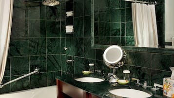 A bathroom with two sinks, a large mirror, a shower, and a towel rack.