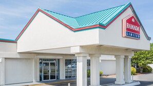 A building with a red and white sign reading "RAMADA LIMITED" and a blue roof. - Ramada Limited Norfolk (Norfolk)