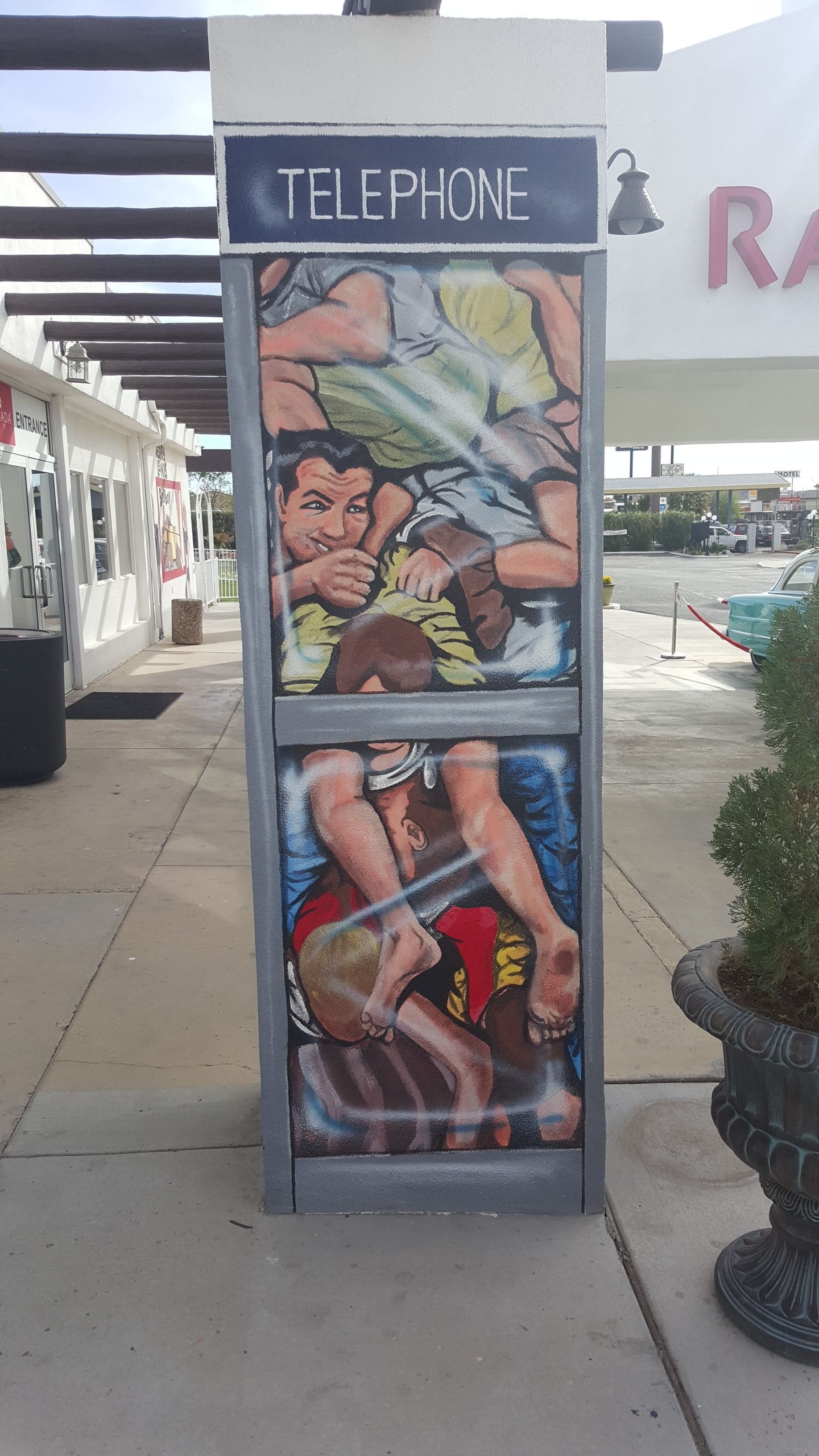 A telephone booth with a mural of two people.