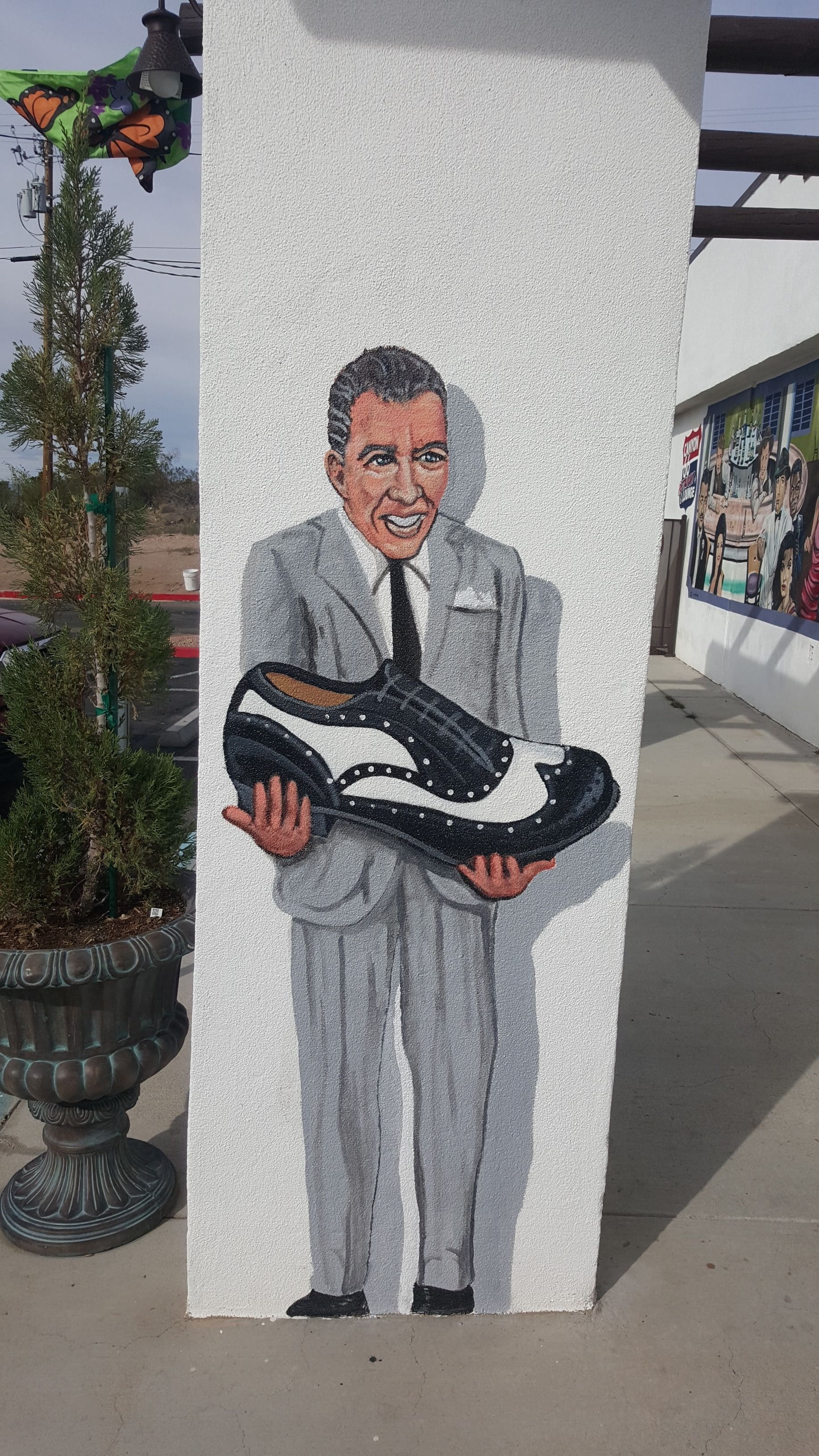 Un mural que muestra a una persona sosteniendo un zapato en una pared.