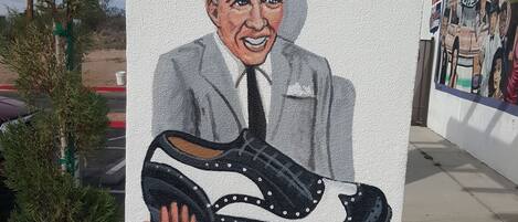 Un mural que muestra a una persona sosteniendo un zapato en una pared.