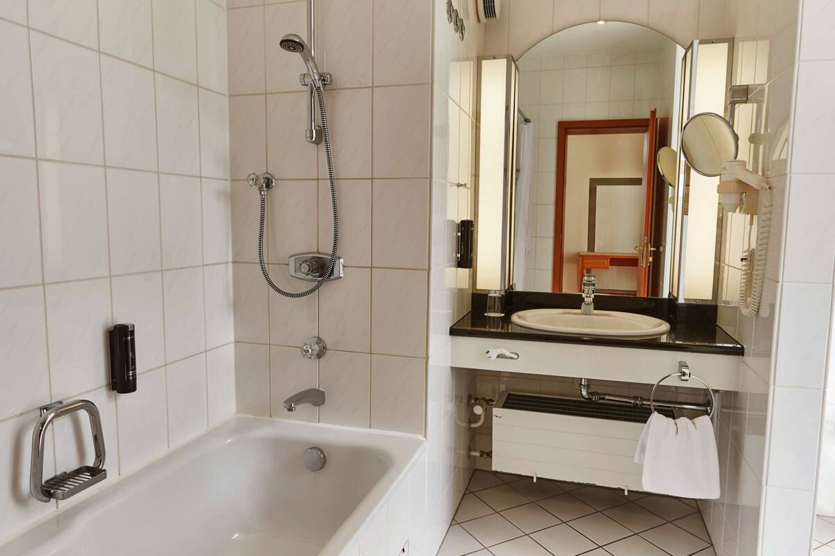 Une salle de bain moderne équipée d’une baignoire, d’un lavabo et d’une douche.