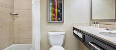 Un baño moderno con bañera, inodoro y tocador con lavamanos.