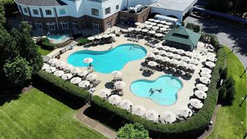 Relax by the pool surrounded by lush greenery and comfortable lounge seating.