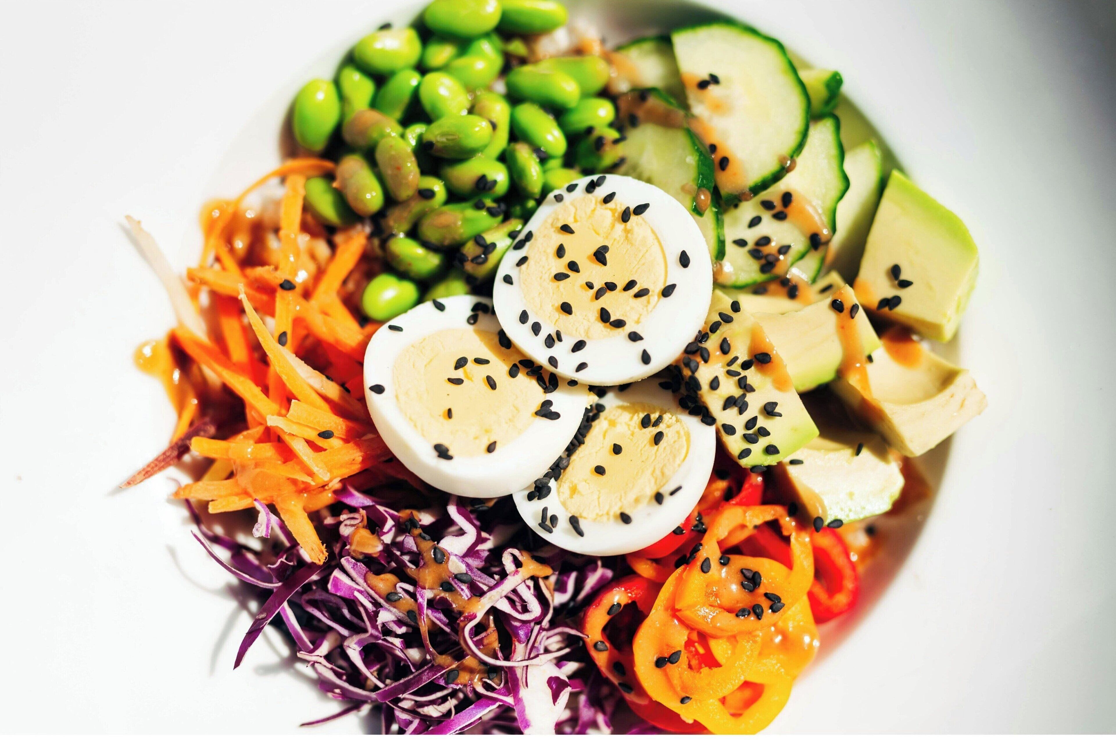 Una ensalada colorida con diferentes verduras y huevos.
