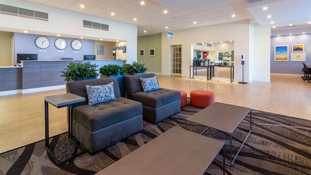 A modern lobby with a reception desk, seating area, and a kitchenette. - Days Inn by Wyndham Titusville Kennedy Space Center (Titusville)