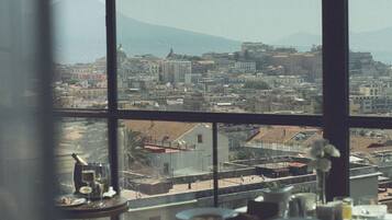 Un dormitorio con un ventanal grande con vistas a un paisaje urbano.