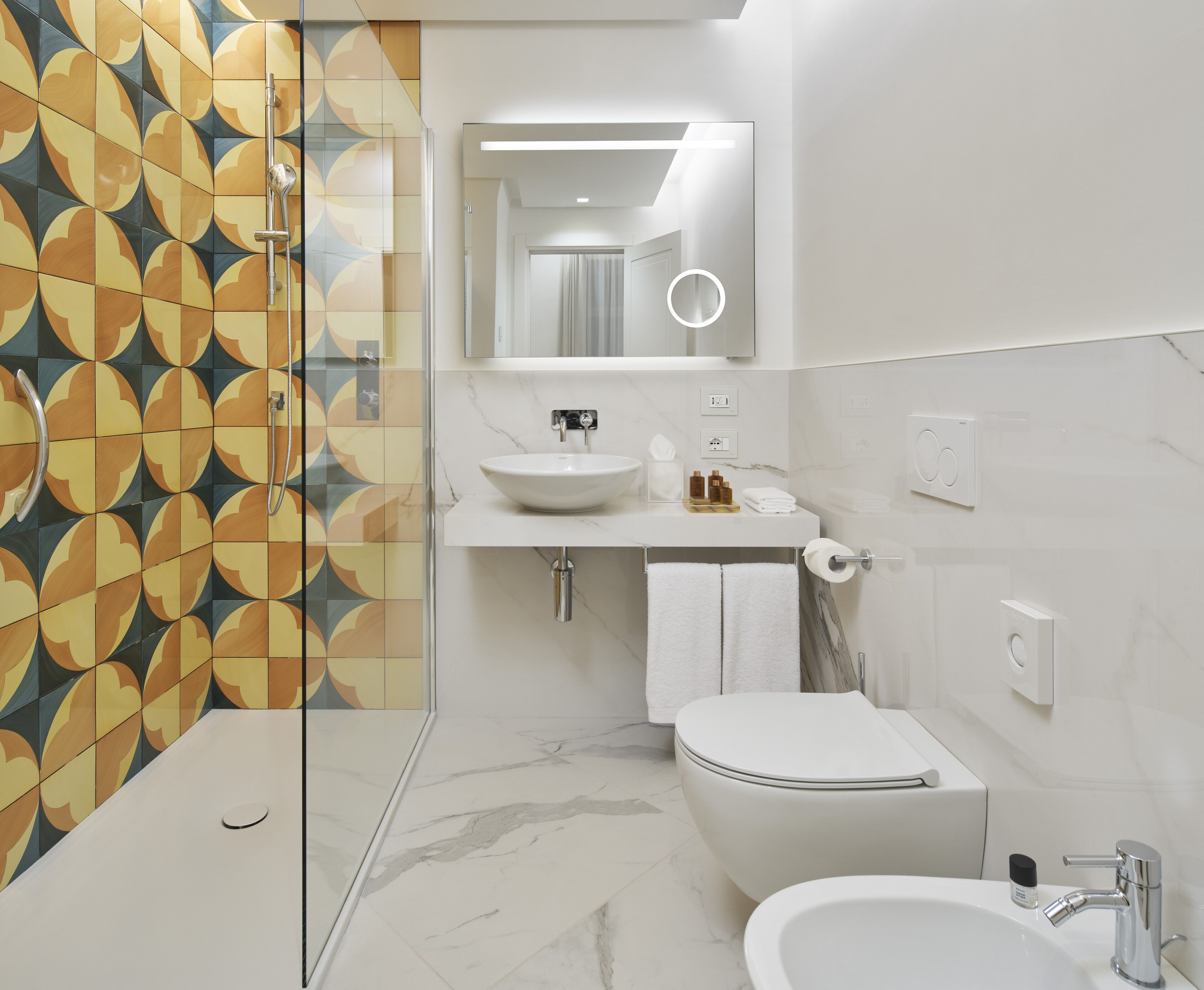 Een moderne badkamer met douche, toilet, wastafel en bidet.