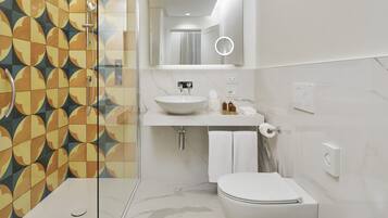 Een moderne badkamer met douche, toilet, wastafel en bidet.