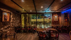 A restaurant with wooden furniture and stone walls.