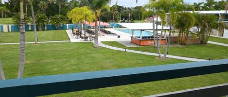 A pool area with lounge chairs, a small building labeled 'Tanya', and palm trees.