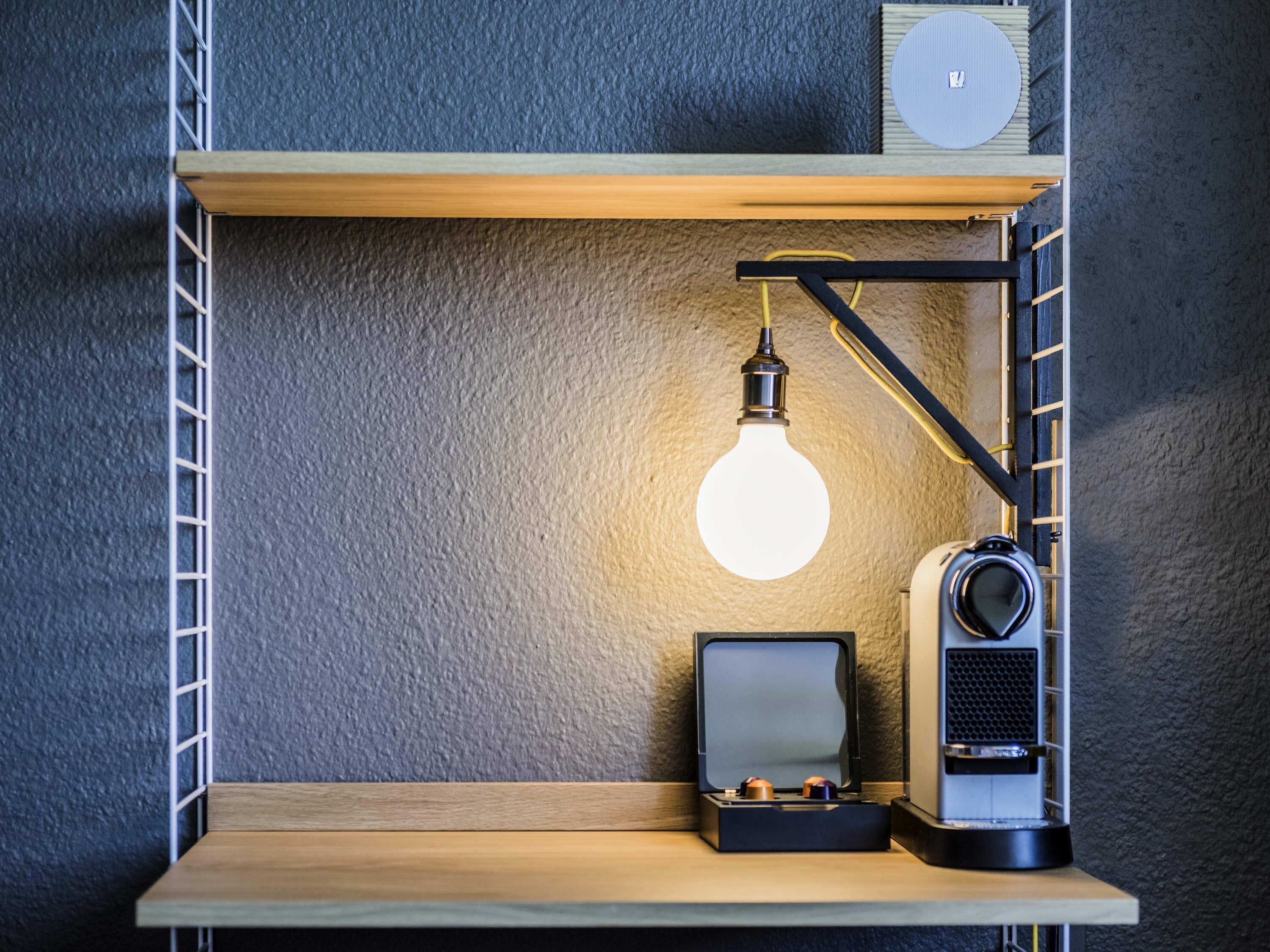 A shelf with a lamp, a speaker, and a small box.